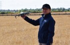 Professor Ji Zhou holding a drone in an arable field